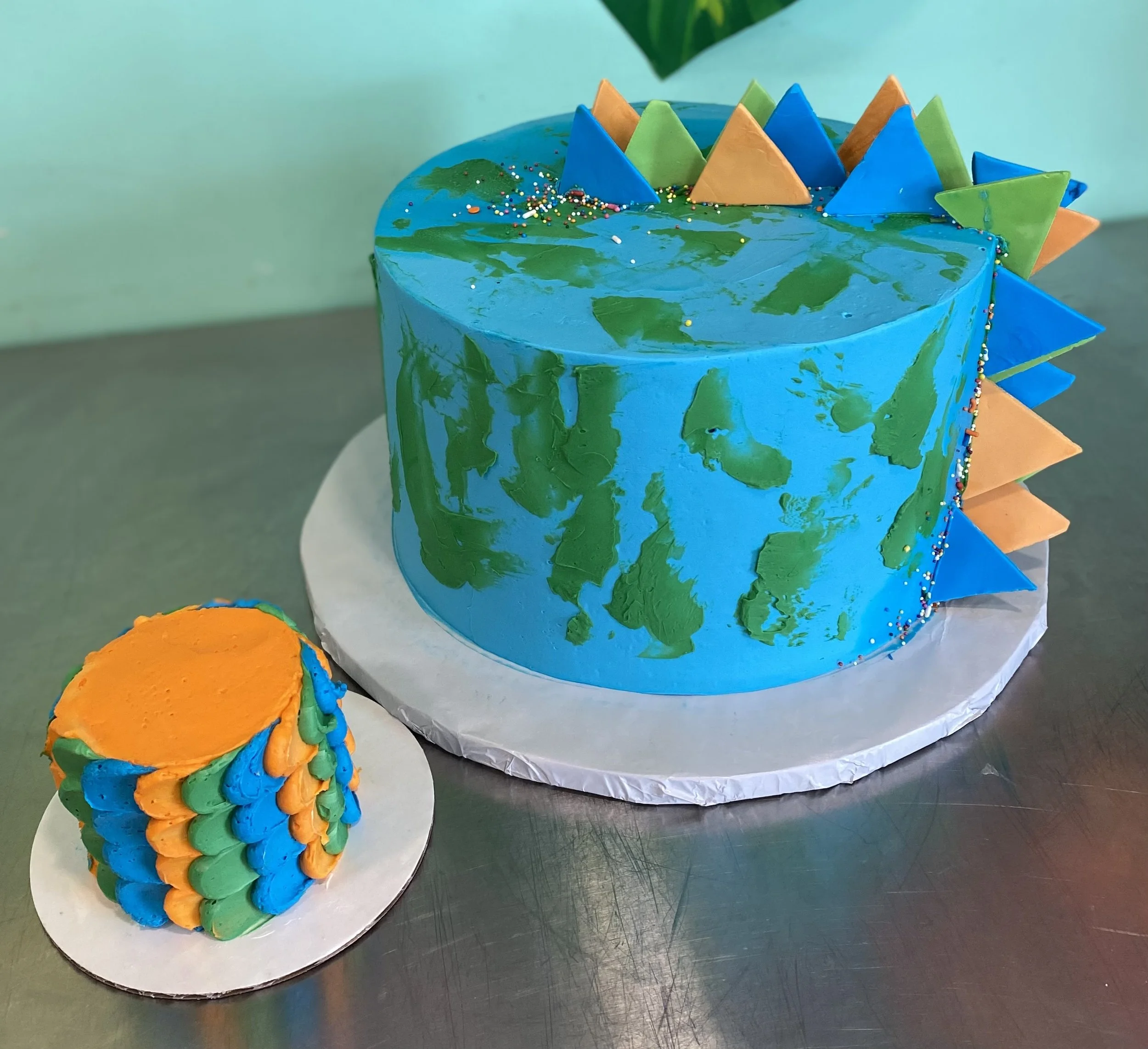 Blue green dinosaur spikes cake