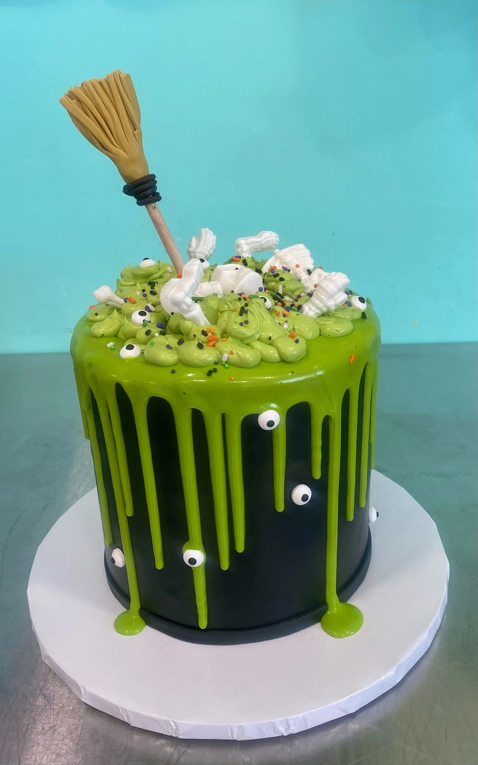 Green witch broom halloween drip cake