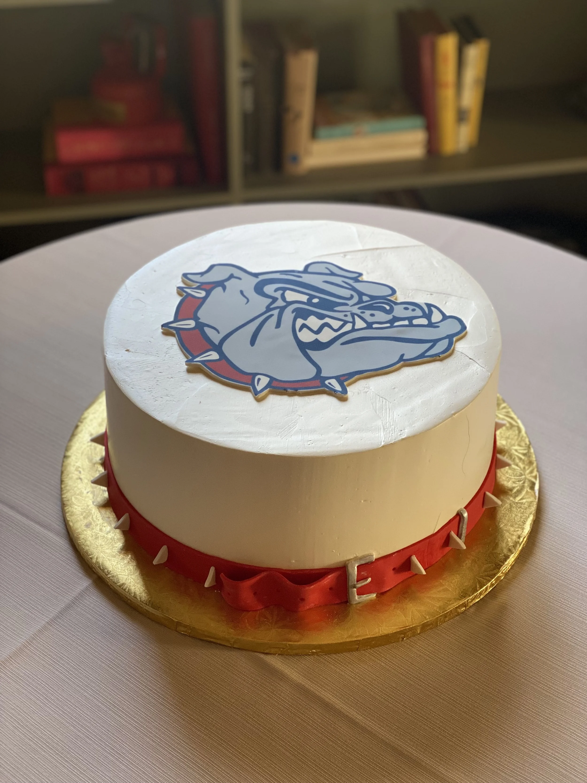 White circular graduation cake school mascot