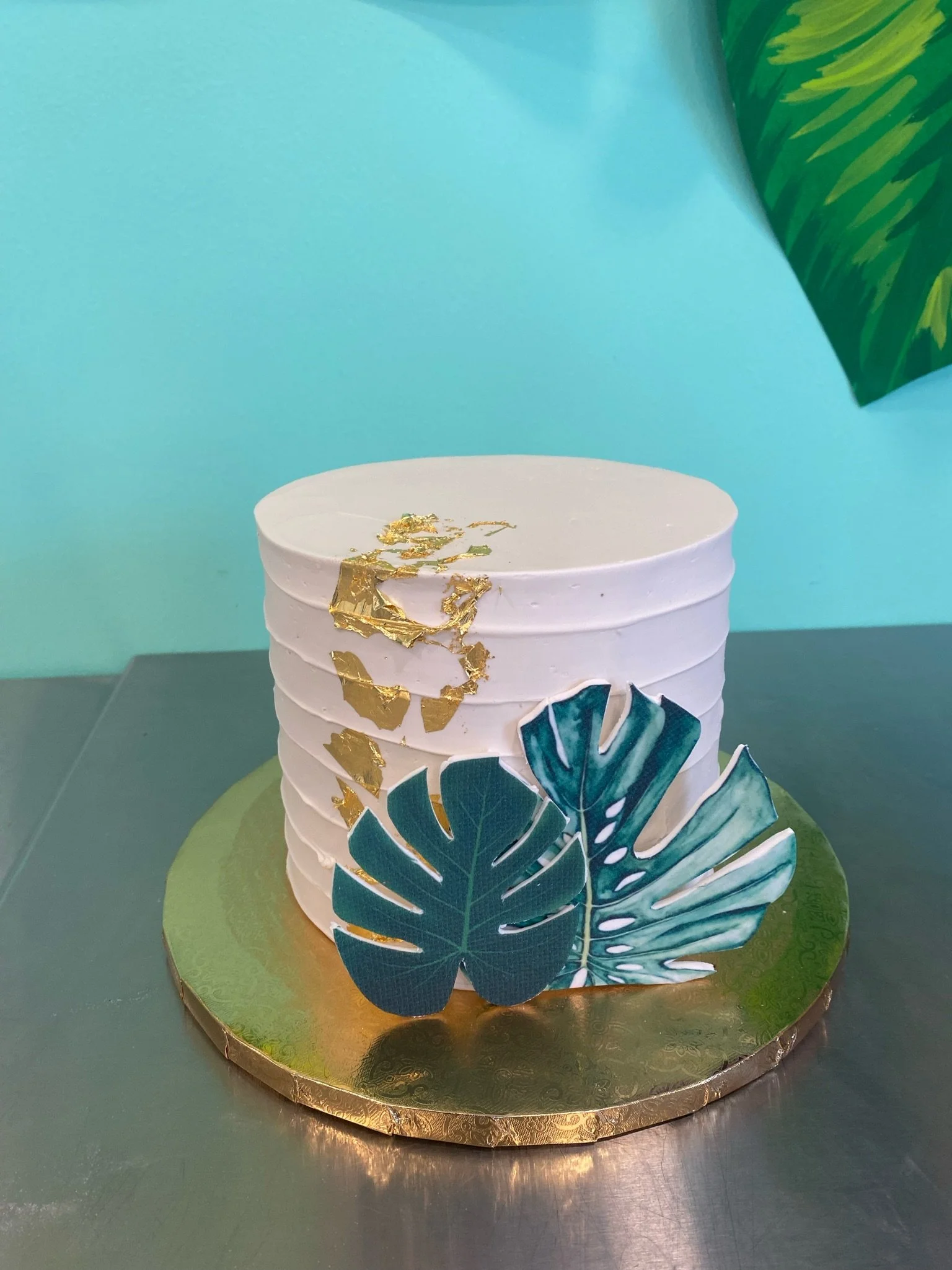 White tropical leaf greenery baby shower cake